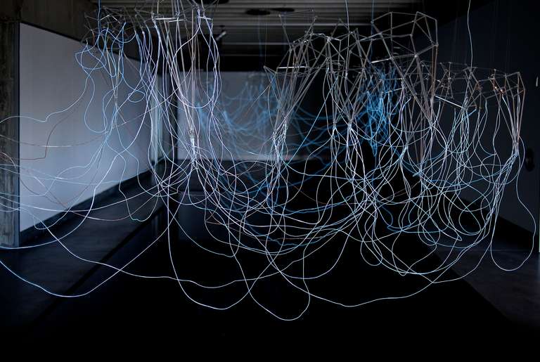 Cloudscape © 2016. Varilla de borosilicato, cable electroluminiscente, fibra de madera, lámina de agua y sonido. 800 x 450 x 350 cm (h)