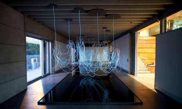 Cloudscape © 2016. Varilla de borosilicato, cable electroluminiscente, fibra de madera, lámina de agua y sonido. 800 x 450 x 350 cm (h)